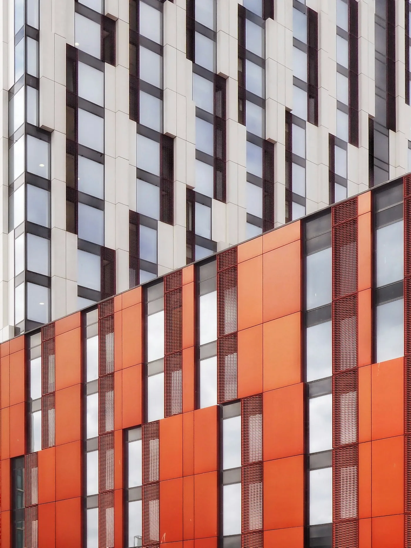 Beyaz ve turuncu panellerle kaplı bina cephesi